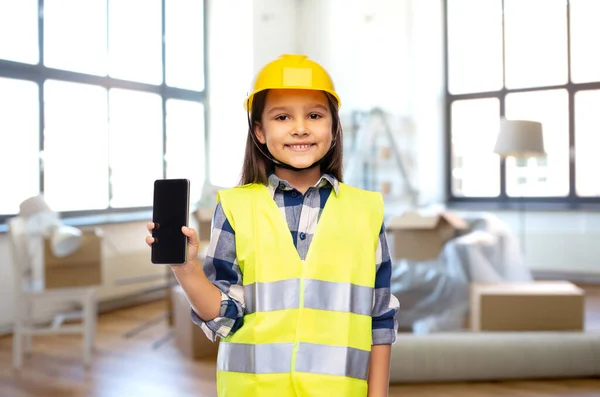 Menina no capacete de construção com smartphone — Fotografia de Stock