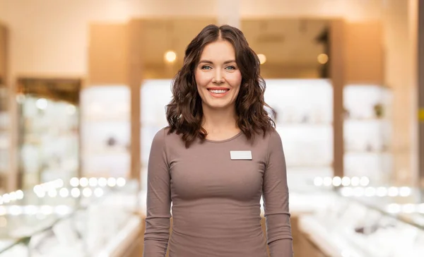 Happy female jewelry shop assistant with name tag — Foto Stock