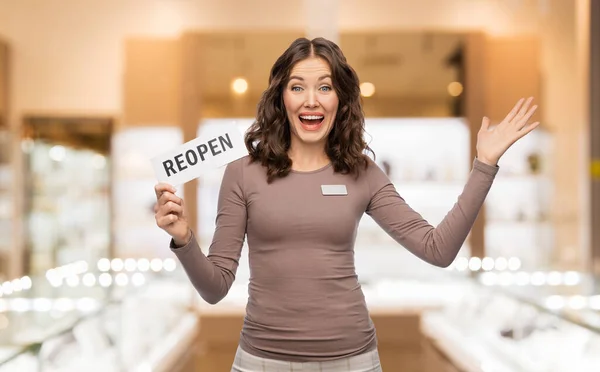 Happy jewelry shop assistant with reopen sign — Stock Fotó