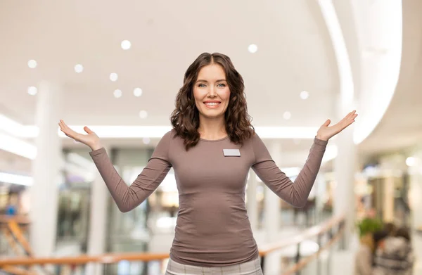 Asistente de tienda femenina feliz con etiqueta de nombre —  Fotos de Stock