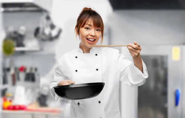 Chef with frying pan tasting food on kitchen — Stockfoto