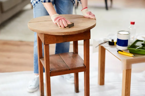 Frau schleift alten runden Holztisch mit Schwamm — Stockfoto
