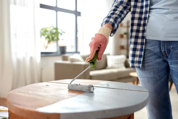 Woman painting old wooden table in grey color — Stock Photo, Image