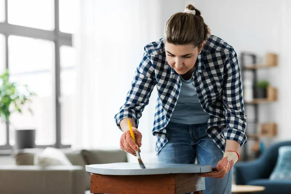 Woman painting old wooden table with grey color — Stock Photo, Image