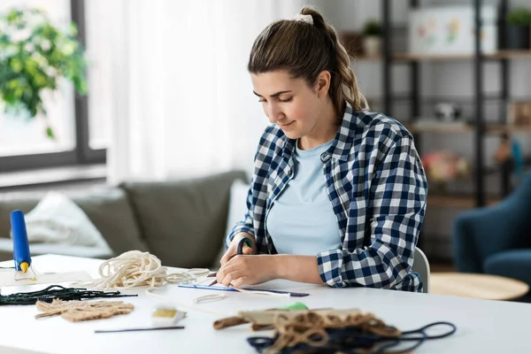 Vrouw snijden macrame koorden met een schaar — Stockfoto