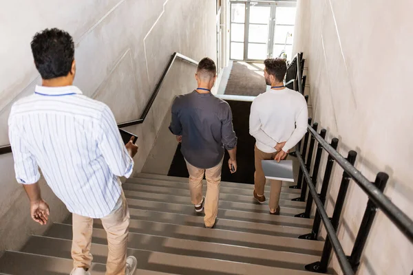 Erkekler ofis merdivenlerinden aşağı iniyor ve konuşuyor. — Stok fotoğraf