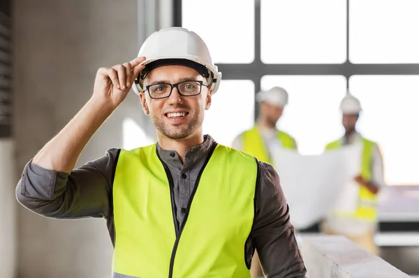 Arquiteto masculino em capacete e segurança oeste no escritório — Fotografia de Stock