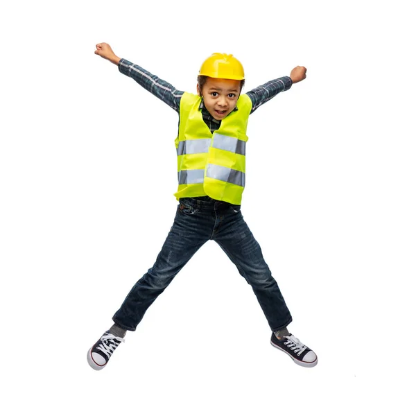 Хлопчик у безпечному жилеті та будівельному шоломі стрибає — стокове фото