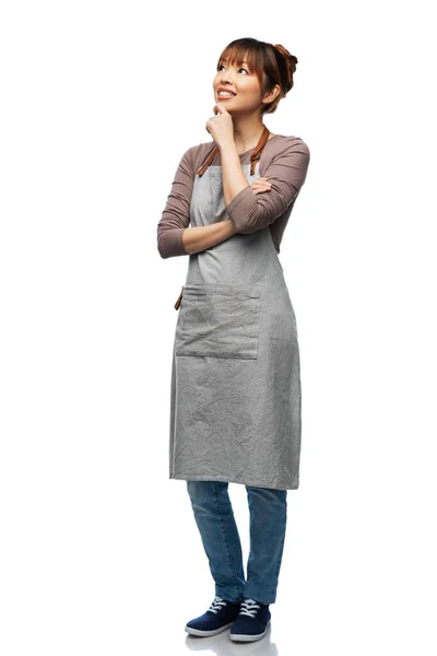 Smiling woman in apron thinking — Stock Fotó
