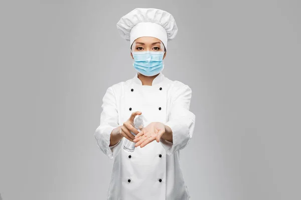 Femme chef masquée utilisant un désinfectant pour les mains ou du savon — Photo