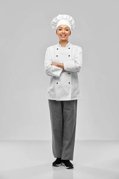 Glimlachende vrouwelijke chef-kok in witte jas — Stockfoto