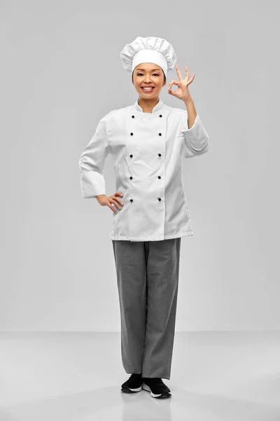 Šťastná usměvavá fena kuchařka ukazující OK znamení ruky — Stock fotografie