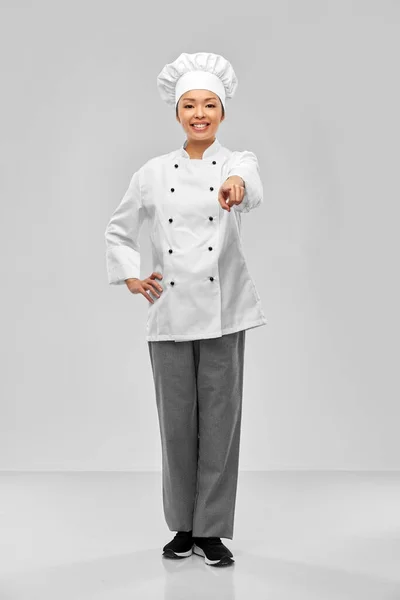 Smiling female chef pointing finger to camera — Zdjęcie stockowe