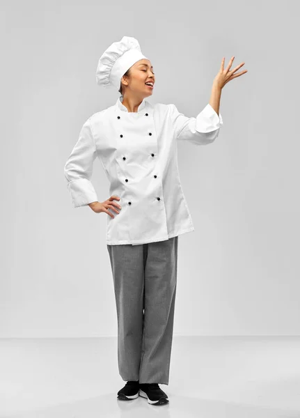 Happy female chef posing over grey background — Foto Stock