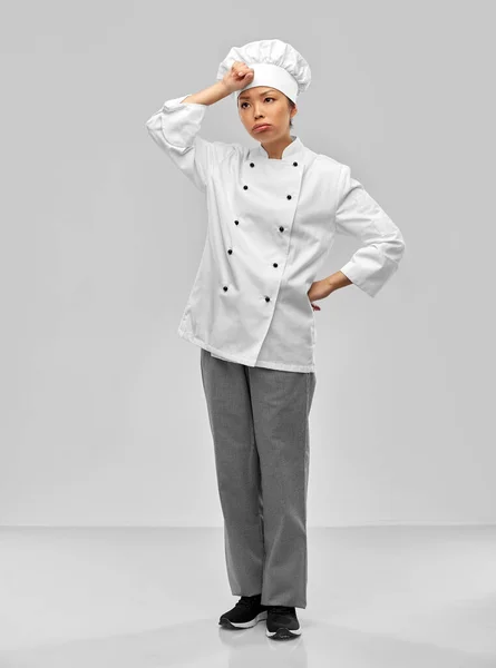 Tired female chef in white jacket — Stockfoto