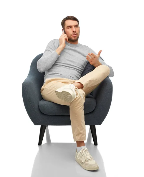 Man sitting in chair calling on smartphone — Stockfoto