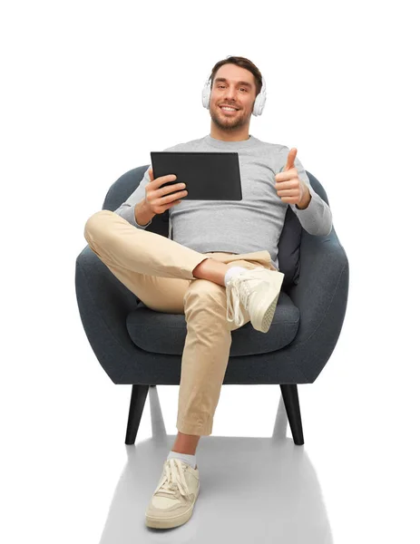 Man with headphones and tablet pc shows thumbs up — Stock fotografie