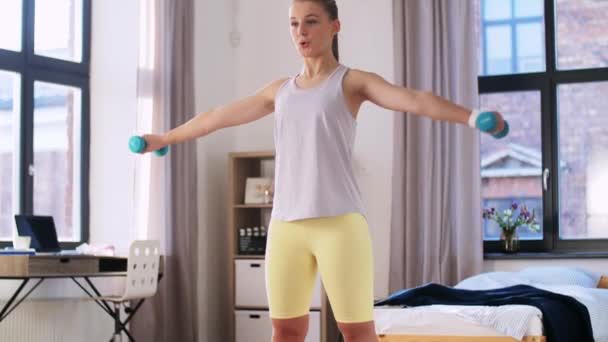 Teenage girl with dumbbells exercising at home — Stock Video
