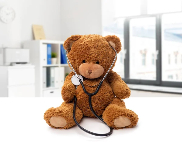 Medvídek se stetoskopem na bílém pozadí — Stock fotografie