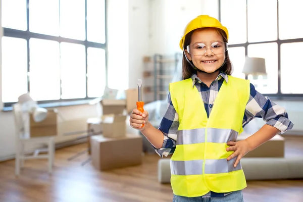 Meisje in helm en veiligheidsvest met schroevendraaier — Stockfoto