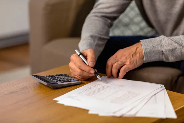 Senior man with bills and calculator at home — Stock Fotó