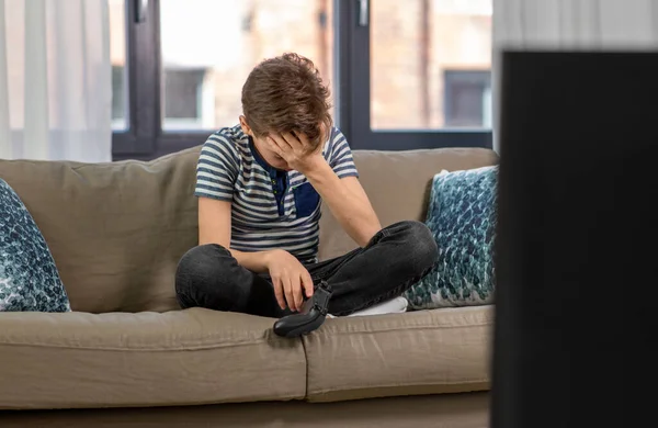 Засмучений хлопчик з геймпад граючи відеоігри вдома — стокове фото