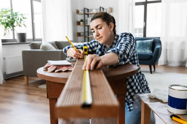 Femme avec règle mesurant la planche en bois — Photo