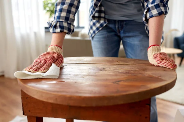 Frau reinigt alte Tischfläche mit Papiertaschentuch — Stockfoto