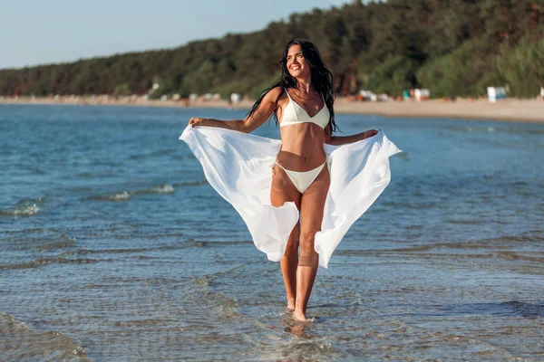 Vrouw in bikini badpak met pareo op het strand — Stockfoto