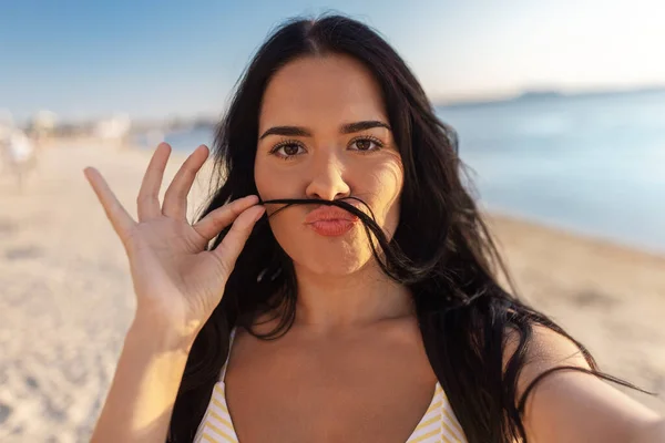 Kobieta z wąsami i robienie selfie na plaży — Zdjęcie stockowe