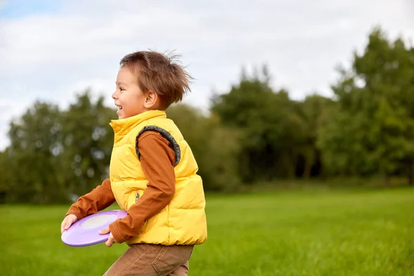 Feliz niño jugando con el disco volador en el parque — Foto de Stock