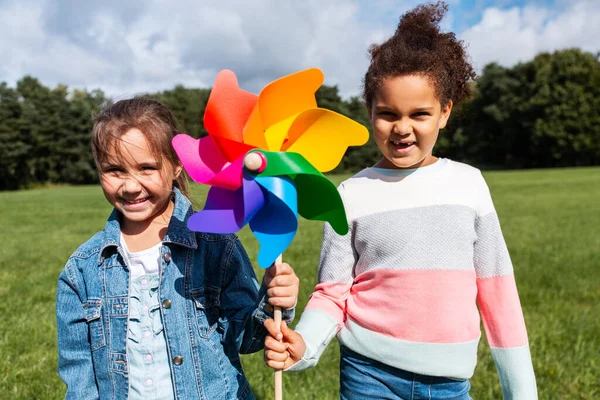 Meninas felizes com pinwheel se divertindo no parque — Fotografia de Stock