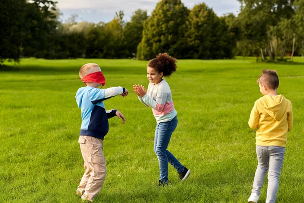 Glückliche Kinder spielen und rennen im Park — Stockfoto