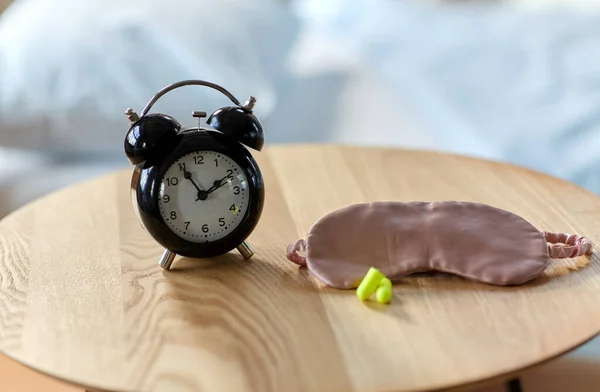 알람 시계, 귀마개, 탁자 위에서 자고 있는 마스크 — 스톡 사진
