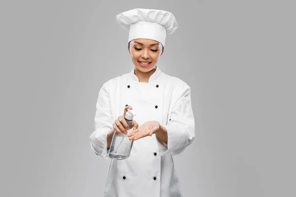Vrouwelijke chef-kok met handreiniger of vloeibare zeep — Stockfoto