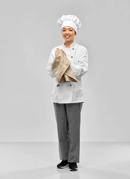 Glimlachende vrouwelijke chef-kok in jas met keukendoek — Stockfoto