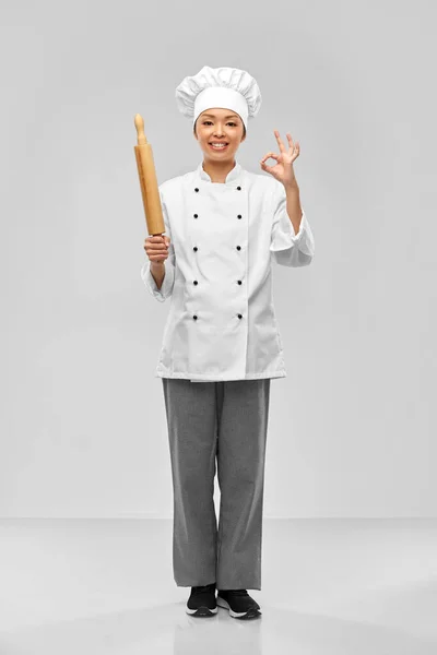 Smiling female chef or baker with rolling pin — Stock Photo, Image