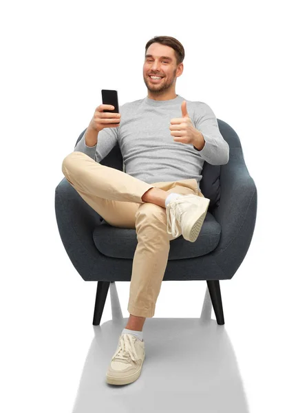 Улыбающийся мужчина со смартфоном показывает большие пальцы вверх — стоковое фото