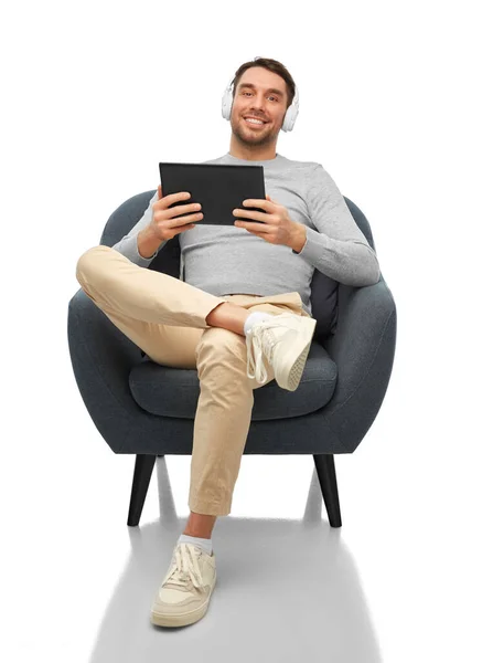 Hombre con auriculares y tablet pc sentado en silla — Foto de Stock