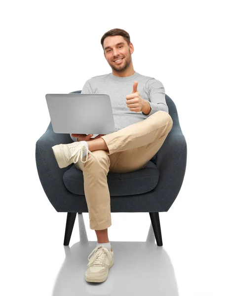 Homem com laptop sentado na cadeira mostrando polegares para cima — Fotografia de Stock