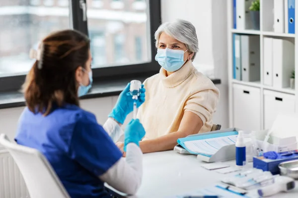 Arzt mit Spritze und Seniorin im Krankenhaus — Stockfoto