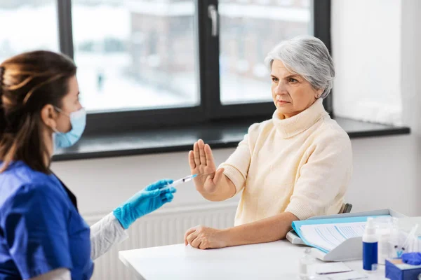 Verpleegster met injectiespuit en vrouw weigert vaccin — Stockfoto