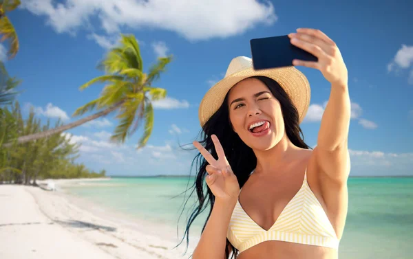 Donna sorridente in bikini scattare selfie sulla spiaggia — Foto Stock