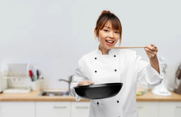 Chef with frying pan tasting food on kitchen — Zdjęcie stockowe