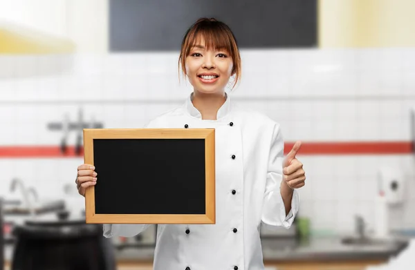 Female chef with chalkboard showing thumbs up — Stockfoto