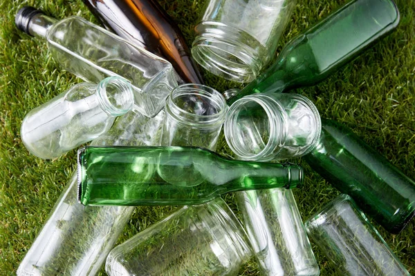 Close up of empty glass bottles and jars on grass — 图库照片