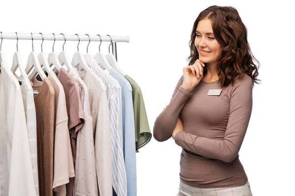 Gelukkig vrouw winkel assistent met kleding op hanger — Stockfoto