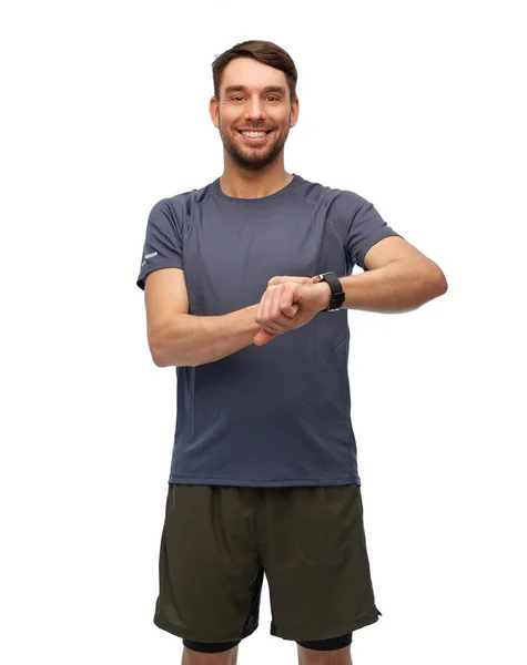 Hombre sonriente con reloj inteligente o rastreador de fitness — Foto de Stock