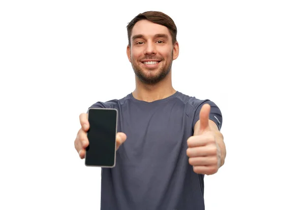 Hombre sonriente en ropa deportiva mostrando teléfono inteligente — Foto de Stock