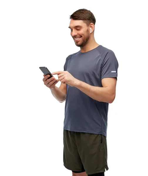 Man in sports clothes with phone and earphones — Stock Photo, Image